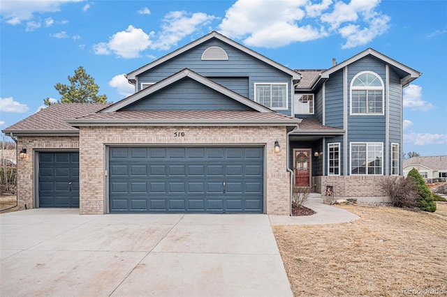 traditional-style home featuring concrete driveway, brick siding, and an attached garage