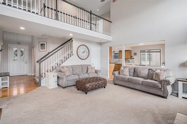 carpeted living room featuring a wealth of natural light, stairway, baseboards, and recessed lighting