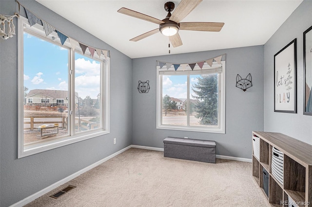 interior space with carpet, visible vents, plenty of natural light, and baseboards