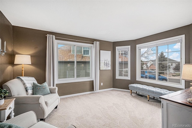 living area featuring carpet flooring and baseboards