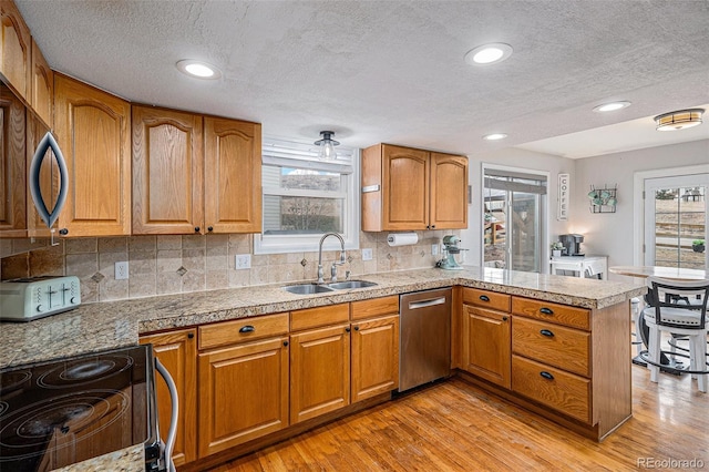 kitchen with dishwasher, black electric range, brown cabinetry, and a sink