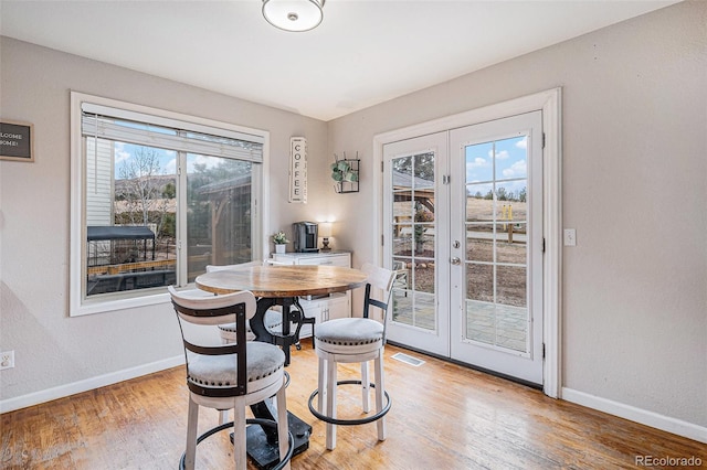 dining area featuring french doors, a wealth of natural light, and baseboards