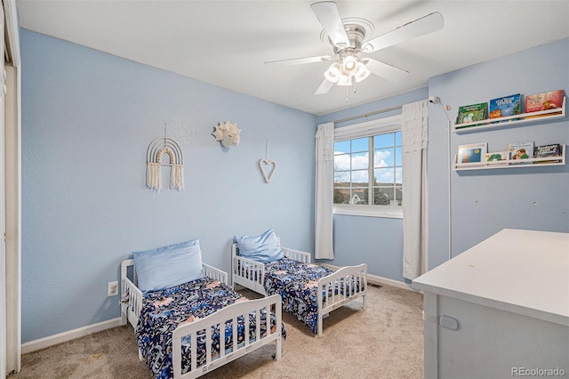 carpeted bedroom with ceiling fan and baseboards