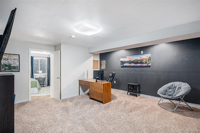 office area with a textured ceiling, baseboards, and carpet flooring