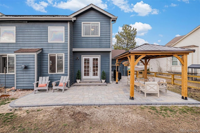 rear view of property with a gazebo, fence, a patio, and french doors