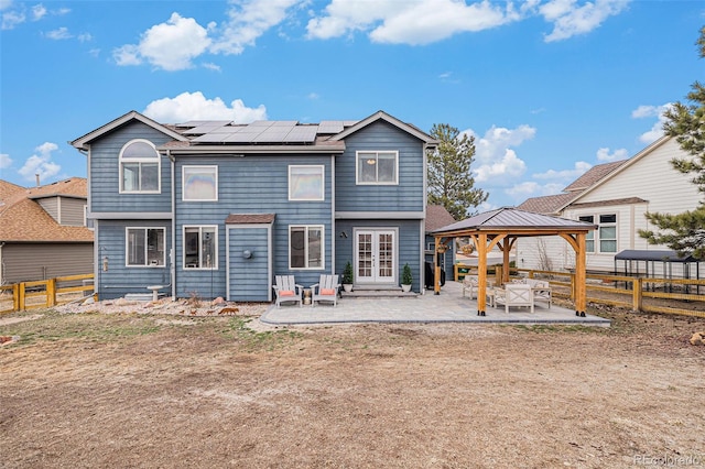 rear view of house featuring french doors, a patio, a gazebo, and solar panels