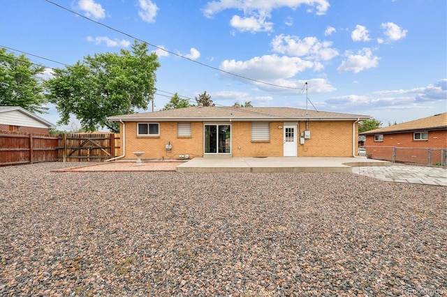 8460 Corona St, Denver, CO 80229 - back of house with a patio area, a fenced backyard, and brick siding