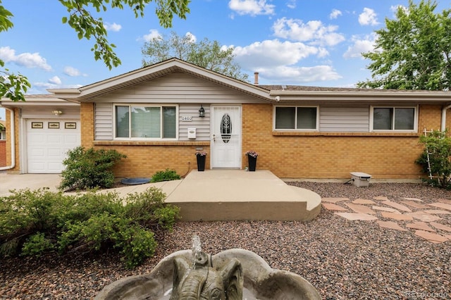 8460 Corona St, Denver, CO 80229 - ranch-style house featuring brick siding, a garage, and driveway