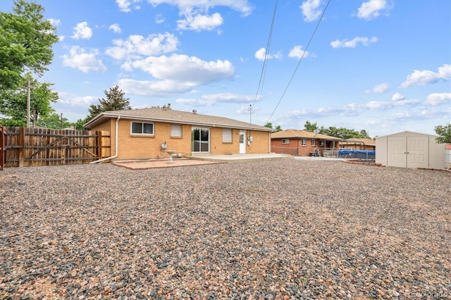 8460 Corona St, Denver, CO 80229 - rear view of house featuring a patio area, a shed, brick siding, and a fenced backyard