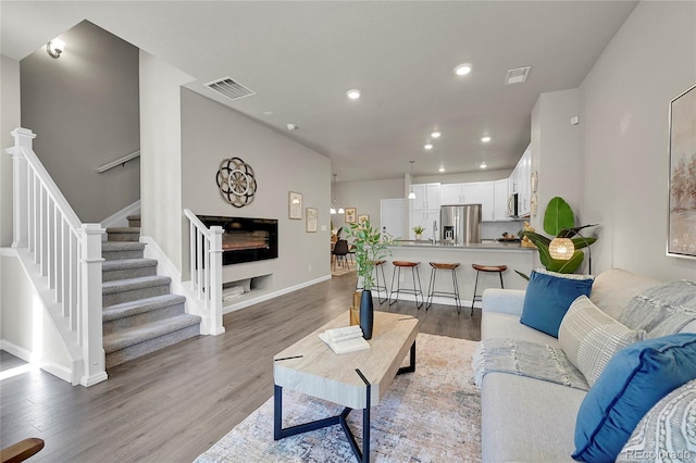 living room with a fireplace and wood-type flooring