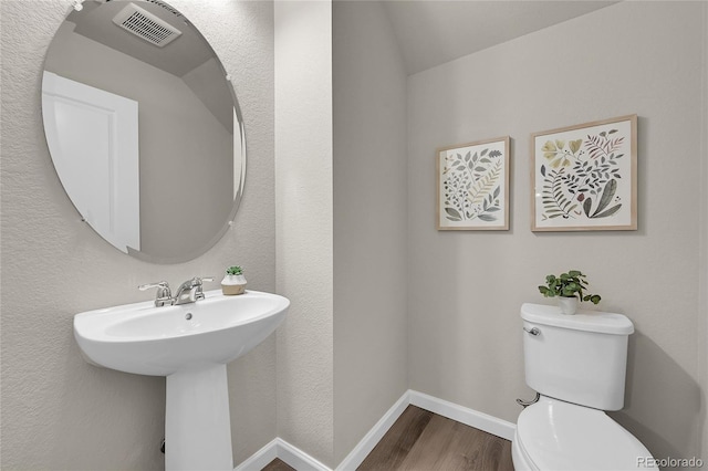 bathroom featuring sink, wood-type flooring, toilet, and vaulted ceiling