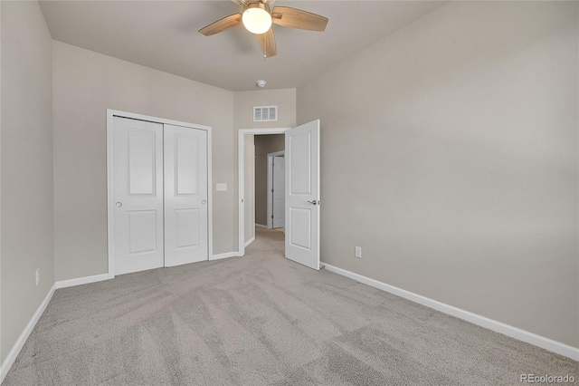 unfurnished bedroom with ceiling fan, light colored carpet, and a closet