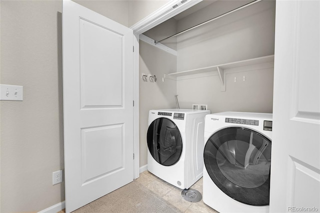 laundry area with light tile patterned floors and washer and clothes dryer