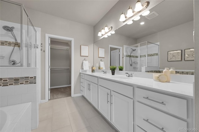 bathroom featuring a sink, double vanity, a shower stall, and tile patterned floors