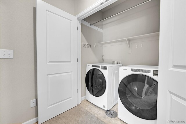 washroom with baseboards, washing machine and dryer, and laundry area
