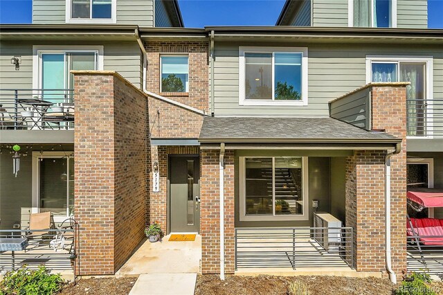 doorway to property with brick siding and a balcony