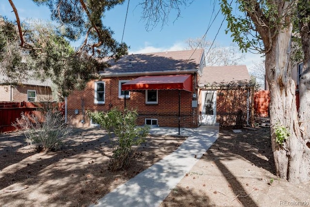 3055 Clermont St, Denver, CO 80207 - view of front facade with fence, brick siding, and a shingled roof