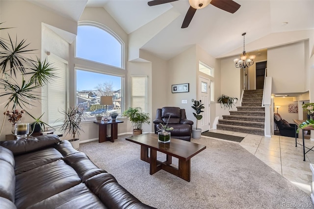 living room with ceiling fan with notable chandelier, high vaulted ceiling, and light tile patterned floors