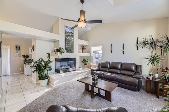 living room featuring a fireplace, high vaulted ceiling, ceiling fan, and light tile patterned flooring