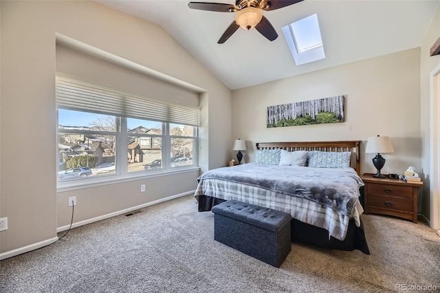 carpeted bedroom with ceiling fan and vaulted ceiling with skylight