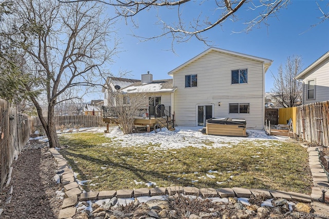 snow covered house featuring a yard, a hot tub, and a deck