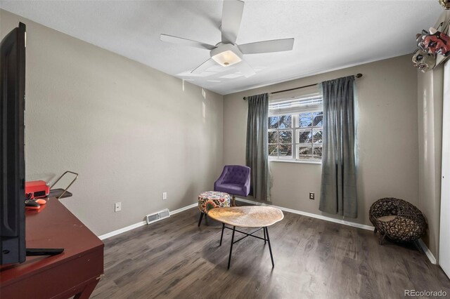 sitting room featuring a ceiling fan, visible vents, baseboards, and wood finished floors