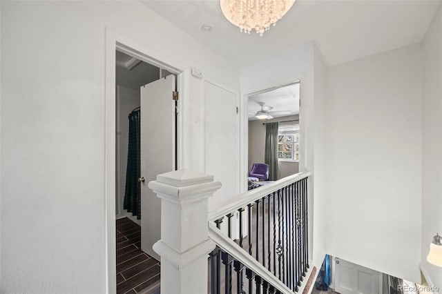 hall featuring an inviting chandelier, baseboards, and wood finish floors