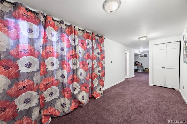 interior space featuring carpet flooring and baseboards