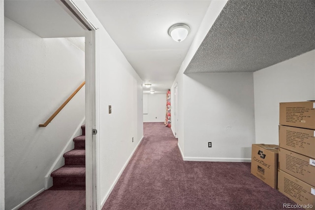 hall with a textured ceiling, stairway, carpet, and baseboards