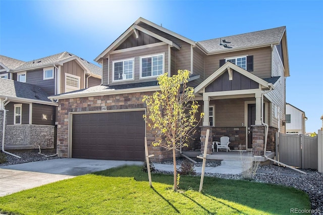 craftsman inspired home with a front yard, a porch, and a garage