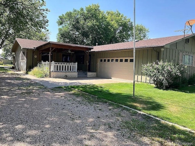 manufactured / mobile home featuring a garage, a front yard, and covered porch