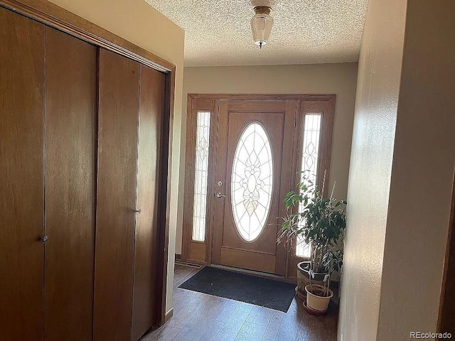 entryway with dark hardwood / wood-style floors and a textured ceiling