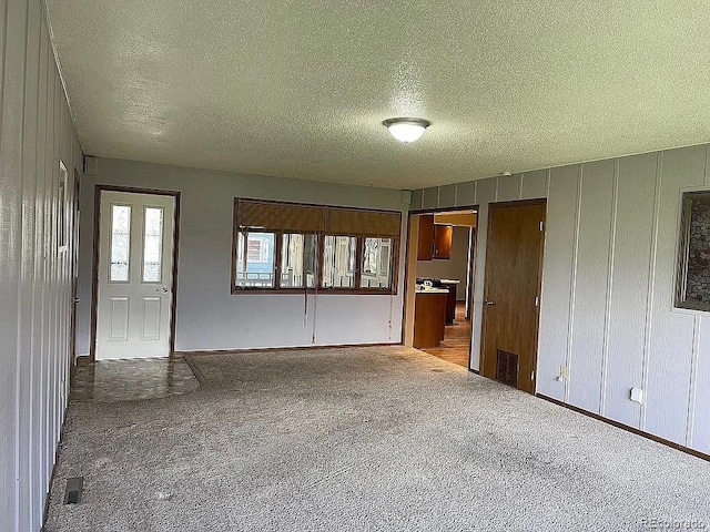 interior space featuring carpet floors and a textured ceiling