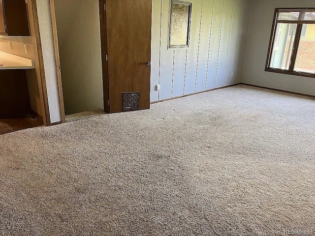 unfurnished bedroom featuring carpet floors and wood walls