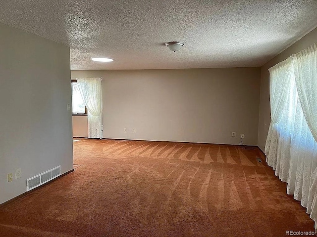 carpeted spare room featuring a textured ceiling