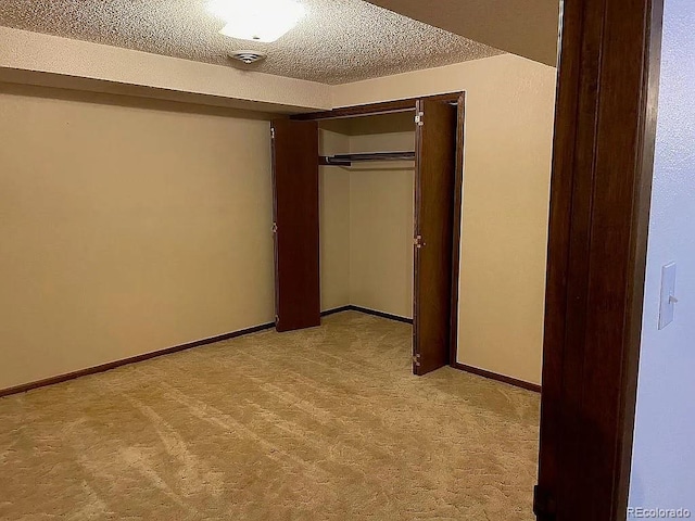 unfurnished bedroom featuring light colored carpet, a textured ceiling, and a closet