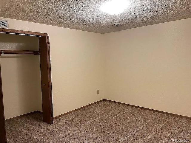 unfurnished bedroom with carpet floors, a closet, and a textured ceiling