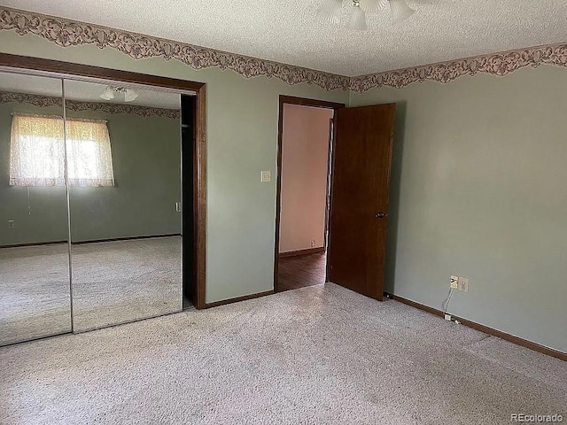 unfurnished bedroom featuring a closet, a textured ceiling, and carpet