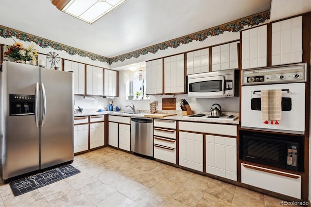 kitchen with sink, light tile patterned floors, white cabinetry, and stainless steel appliances