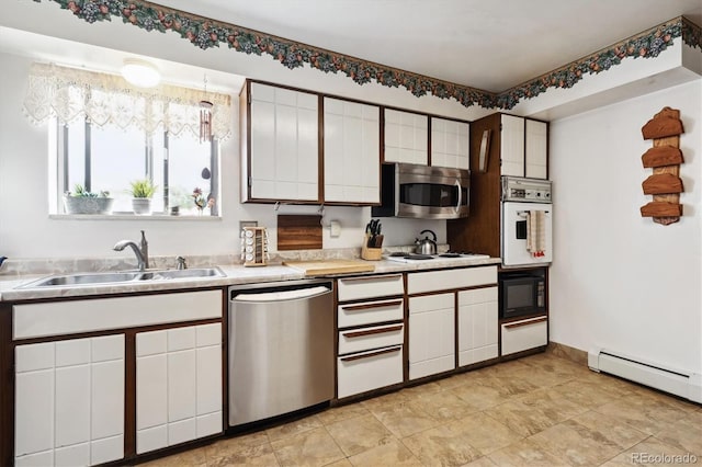 kitchen with stainless steel appliances, a baseboard heating unit, sink, white cabinets, and light tile patterned floors