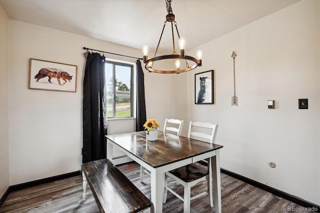 dining space with baseboard heating, dark wood-type flooring, and a chandelier