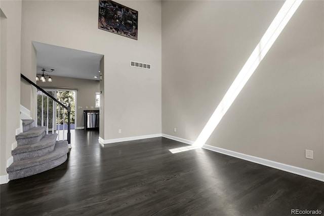 11565 Crow Hill Dr, Parker, CO 80134 - unfurnished living room with dark wood-style flooring, stairway, and a high ceiling