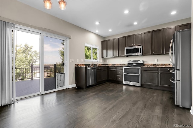11565 Crow Hill Dr, Parker, CO 80134 - kitchen featuring stainless steel appliances, dark wood-style floors, recessed lighting, dark stone countertops, and dark brown cabinetry