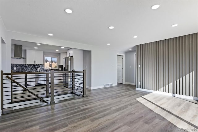 unfurnished living room with recessed lighting, baseboards, visible vents, and wood finished floors