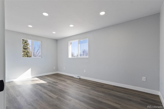 spare room with recessed lighting, baseboards, visible vents, and dark wood-type flooring