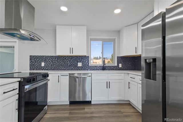 kitchen with wall chimney range hood, appliances with stainless steel finishes, recessed lighting, and a sink
