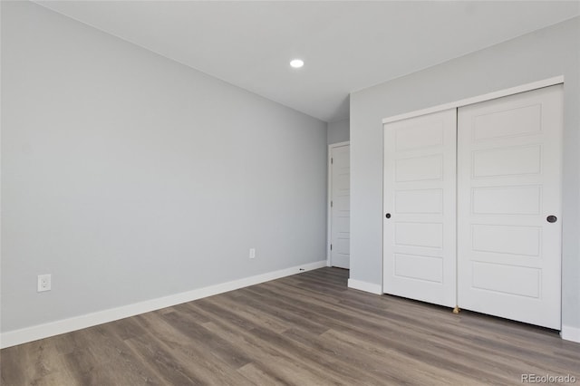 unfurnished bedroom featuring recessed lighting, baseboards, wood finished floors, and a closet