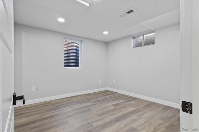 below grade area with recessed lighting, baseboards, visible vents, and wood finished floors
