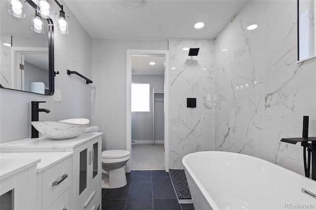 bathroom with a sink, double vanity, toilet, recessed lighting, and a soaking tub