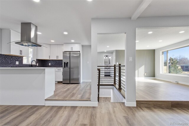 kitchen featuring white cabinets, stainless steel refrigerator with ice dispenser, island exhaust hood, and light wood-style flooring